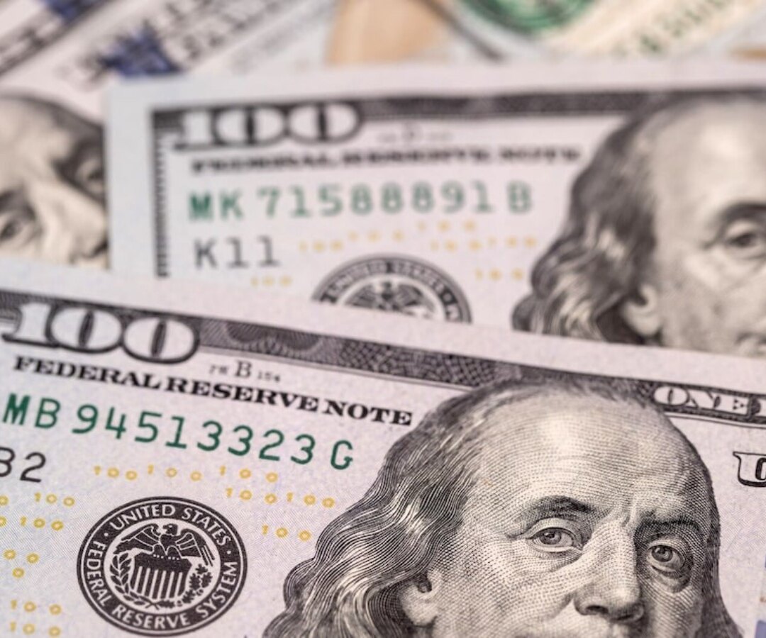 Billetes de cien dólares estadounidenses superpuestos, con el retrato de Benjamin Franklin en primer plano