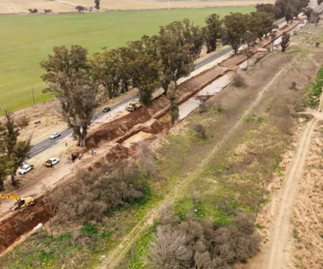 Vista aérea de una retroexcavadora trabajando en el ensanche de un canal de desagüe