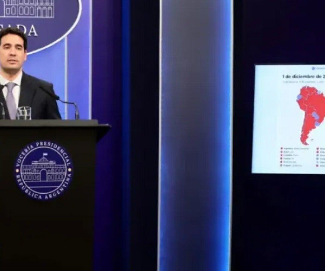 Funcionario en el atril de la Vocería Presidencial en Casa Rosada, con gráficos proyectados en una pantalla